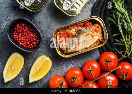 atlantic Makrele in Blechdose, Scombridae geöffnete und geschlossene Dosen kein Etikett, mit Bio-Gemüse Kräuter und Zitronen Draufsicht close up . Stockfoto