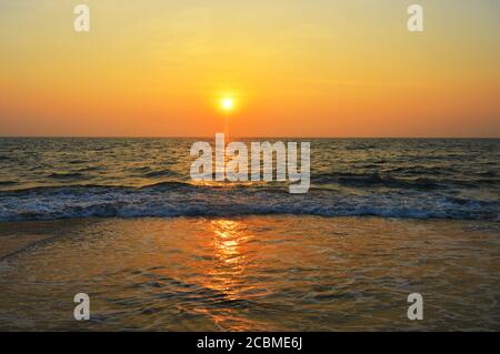 Bild zeigt untergehende Sonne am Strand. Ein Sonnenuntergang steht für Ende, Romantik, Dämmerung, Beginn der Dunkelheit, Veränderung, Transformation und Natur. Stockfoto