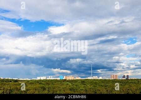 Blauer wolkig Himmel über Wohngebieten und grünen Stadtpark In der Stadt am sonnigen Sommertag Stockfoto