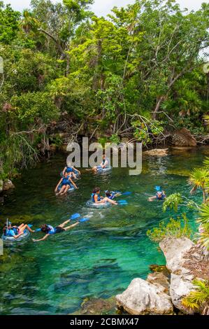 Im Xel-Ha Park, einem kommerziellen Wasserpark und Ökotourismus-Entwicklung an der Karibik, schweben Menschen in Innenrohren auf einem kleinen Fluss Stockfoto