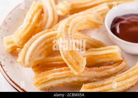 Churros mit Puderzucker und Schokoladensauce. Stockfoto