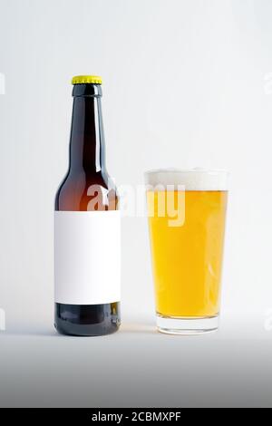 Bierflasche Mock-up mit Glas Lager und Schaum. Leeres Etikett auf weißem Hintergrund Stockfoto