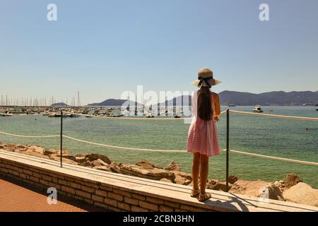 Ein langhaariges kleines Mädchen (9-10 J.) von hinten bewundert den Golf der Dichter mit dem Vorgebirge von Porto Venere im Sommer, Lerici, La Spezia, Italien Stockfoto