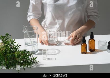Der Wissenschaftler, Dermatologe testet das organische Naturkosmetikprodukt im Labor. Fläschchen, Laborflaschen aus Glas. Kosmetische Forschung Stockfoto