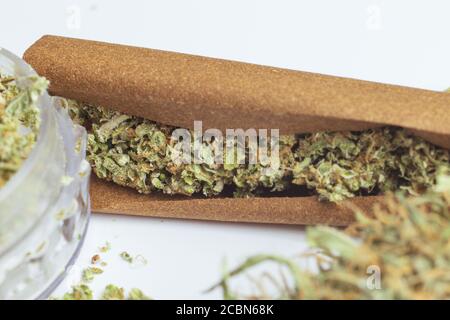 Zerbröckelte medizinische Cannabisknospen in stumpfem Papier aus nächster Nähe. Rauchen legal Marihuana. Weed Lifestyle Stockfoto