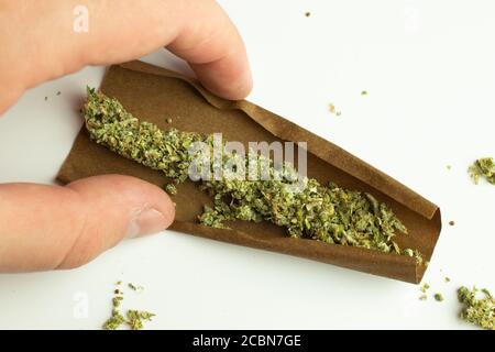 Stumpf von Unkraut auf weißem Hintergrund Draufsicht. Cannabis in Papier zum Rauchen gerollt. Drogenkonsum für den Freizeitgebrauch Stockfoto