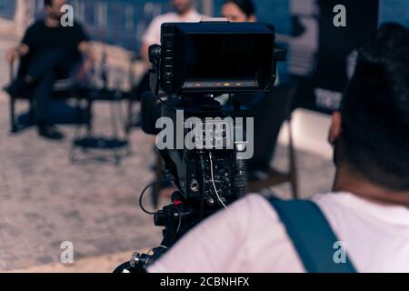 Hinter dem Szenenkonzept. Kameramann arbeitet an professionellen Kamera nehmen Film Interviewer Interview Berühmtheit Menschen machen Nachrichten im Freien. Stockfoto