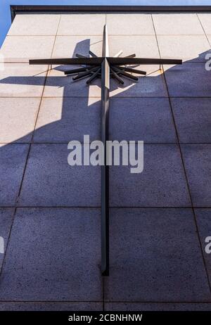 Versteckt in einer Ecke, ist die Hälfte des Kreuzes normalerweise im Schatten auf Douglas Ellingtons Art Deco First Baptist Church in Asheville, NC, USA Stockfoto