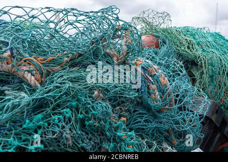 Fischernetze im Bündel auf trockenem Land Stockfoto