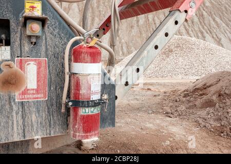 Feuerlöscher an der Bergbauausrüstung des Steinbruchs aufgehängt Stockfoto