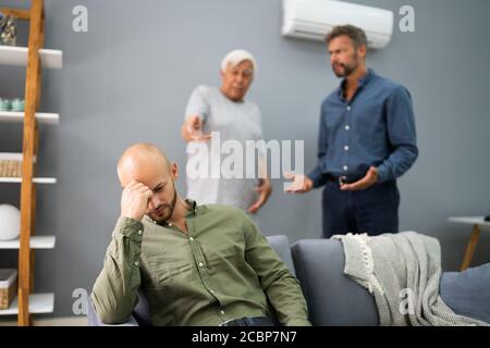 Großvater Mit Konflikt Mit Vater, Während Traurige Sohn Auf Der Couch Sitzen Stockfoto