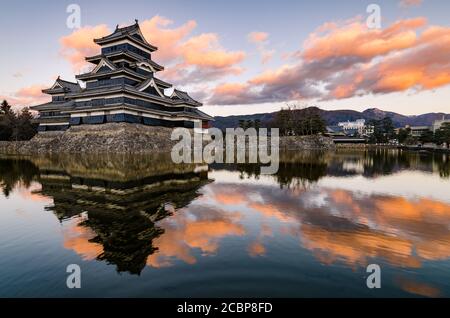 Goldene Lichter Sonnenuntergang Spiegelbild Landschaft auf Matsumoto Schloss im Winter. Wahrzeichen in Matsumoto, Nagano, Japan. Stockfoto