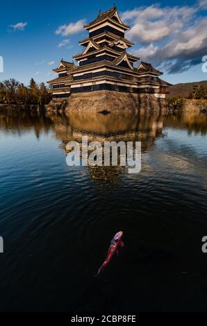 Goldene Lichter Sonnenuntergang Spiegelbild Landschaft auf Matsumoto Schloss im Winter. Wahrzeichen in Matsumoto, Nagano, Japan. Stockfoto