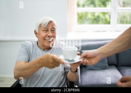 Alte Patienten Zu Hause Pflege Krankenschwester Bringen Tee Stockfoto