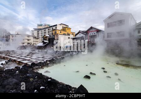 Tagesansicht von Yubatake, einem Hauptsymbol von Kusatsu Onsen, wo heißes Wasser durch Holzkanäle aus Pinienwald strömt. Stockfoto