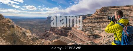 Fotograf, Tourist an der Moki Dugway, Serpentinen durch die steile Wand der Cedar Mesa, Blick auf das Tal der Götter, Bären Ohren National Stockfoto