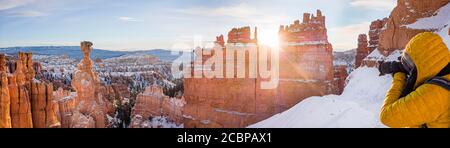 Touristen fotografieren, Felsformation Thors Hammer, Morgenlicht, Sonnenaufgang, bizarre verschneite Felslandschaft mit Hoodoos im Winter, Navajo Loop Trail Stockfoto
