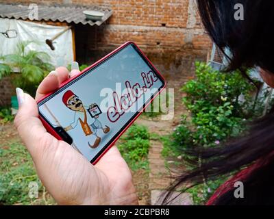 DISTRIKT KATNI, INDIEN - 27. APRIL 2020: Ein indisches Mädchen präsentierte E-lala Cartoon-Logo auf Smartphone-Bildschirm, für E-Commerce-Lernbewusstsein Konzept. Stockfoto