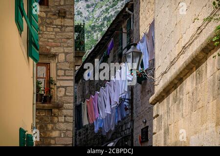 Malerische enge Gassen der gut erhaltenen mittelalterlichen Altstadt mit Wäschestaukerei außerhalb in Kotor, Montenegro auf dem Balkan Stockfoto