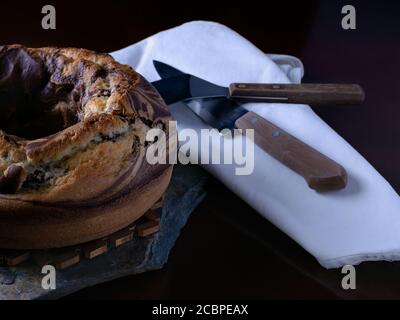 Nahaufnahme eines leckeren hausgemachten Marmorkuchen Ein Schieferbrett mit Küchenutensilien Stockfoto