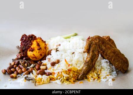 Beliebte Street Food in Malaysia und Singapur bekannt als Nasi Lemak, aus duftendem Kokosmilchreis mit gebratenem Huhn, Sardellen, Erdnüssen, e serviert Stockfoto