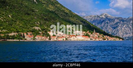 Panoramasicht auf die historische Stadt Perast an der weltberühmten Bucht von Kotor an einem sonnigen Tag mit Bergen im Hintergrund, Montenegro Stockfoto