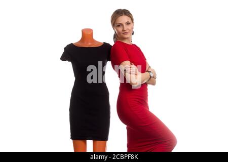 Eine junge Frau in einem roten Kleid und eine Schaufensterpuppe in einem schwarzen Kleid. Isoliert auf weiß Stockfoto