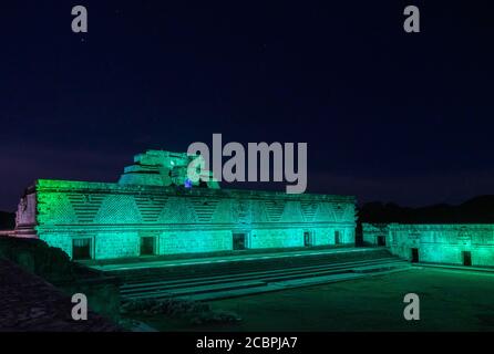 Das östliche Gebäude des Nunnery Quadrangle und die Pyramide des Magiers dahinter sind in den prähispanischen Maya-Ruinen von Uxmal, Mexiko, beleuchtet. Stockfoto