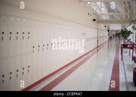 Beigefarbene Schulschließfächer in leerstehenden Schulfluren Stockfoto