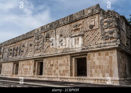 Der Fries des Westgebäudes im Nonnenkomplex in den prähispanischen Maya-Ruinen von Uxmal, Mexiko, ist mit geschnitzten Steinfiguren, geomet, verziert Stockfoto