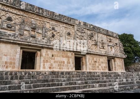 Der Fries des Westgebäudes im Nonnenkomplex in den prähispanischen Maya-Ruinen von Uxmal, Mexiko, ist mit geschnitzten Steinfiguren, geomet, verziert Stockfoto