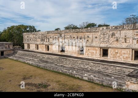 Der Fries des Westgebäudes im Nonnenkomplex in den prähispanischen Maya-Ruinen von Uxmal, Mexiko, ist mit geschnitzten Steinfiguren, geomet, verziert Stockfoto