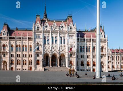 Bewaffnete ungarische Ehrengarde marschieren auf dem Kossuth-Platz vor dem ungarischen Parlament Orszaghaz um die Nationalflagge. Stockfoto