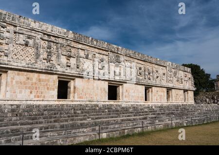 Der Fries des Westgebäudes im Nonnenkomplex in den prähispanischen Maya-Ruinen von Uxmal, Mexiko, ist mit geschnitzten Steinfiguren, geomet, verziert Stockfoto