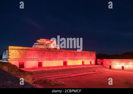 Das östliche Gebäude des Nunnery Quadrangle und die Pyramide des Magiers dahinter sind in den prähispanischen Maya-Ruinen von Uxmal, Mexiko, beleuchtet. Stockfoto