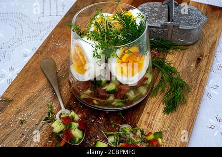 Gesunder Snack aus gekochten Eiern, Salat und frischen Kräutern Stockfoto