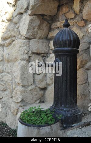 Vertikaler Schuss eines schwarzen Hydranten in der Nähe eines alten Gebäude Stockfoto