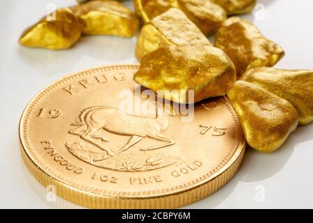 goldene südafrikanische krugerrand eine Unze Münze auf einem Haufen von goldenen Nuggets, goldenes Erz auf weißem Hintergrund isoliert mit viel Kopieplatz Stockfoto