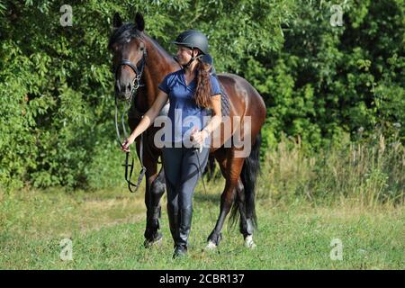 Reiter mit dem Pferd zu Fuß im Freien Stockfoto