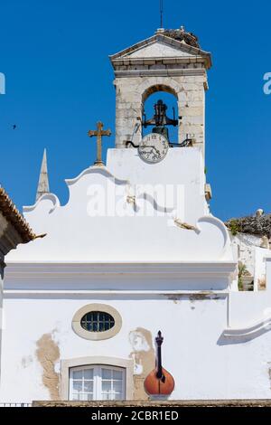 Storch nistet auf Arco da Vila, einem mittelalterlichen Tor in Faro, Algarve, Portugal Stockfoto