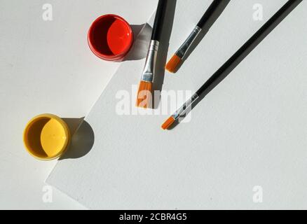 Acrylfarben, Pinsel und Malleinwand. Von oben geschossen Stockfoto