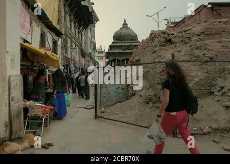 Fußgänger zu Fuß auf einer Gasse zwischen Wohngebiet und einem kulturellen Erbe Ort durch die Erdbeben 2015 in Kathmandu, Nepal betroffen. Stockfoto