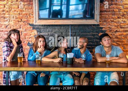 Eine Gruppe von Freunden, die zusammen in einem Pub sitzen und feiern. Stockfoto