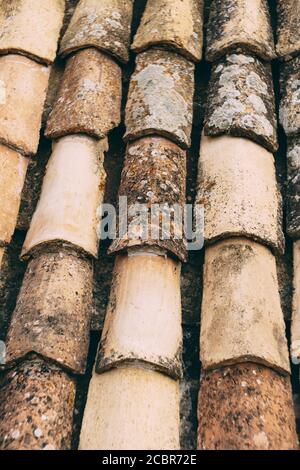 Die Textur der alten braunen Schindeln auf dem Dach des Gebäudes. Stockfoto