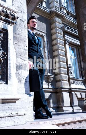 Junger Geschäftsmann warten draußen auf der Straße Stockfoto