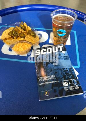 Ein Glas Bier, eine Nachos-Schüssel und ein Spielheft auf dem Tisch. Indianapolis, Indiana / USA Stockfoto