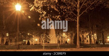 Brunnen in Zrinjevac, einer der schönsten Parks in Zagreb. Nachtfoto, Langzeitbelichtung, Bank für Liebhaber Stockfoto