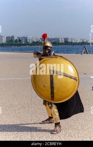 Mann gekleidet als ein alter griechischer Hoplite-Soldat, um Kunden auf eine Mini-Kreuzfahrt in Thessaloniki Griechenland zu locken - Foto: Geopix/Alamy Stock Photo Stockfoto