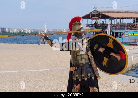 Mann gekleidet als ein alter griechischer Hoplite-Soldat, um Kunden auf eine Mini-Kreuzfahrt in Thessaloniki Griechenland zu locken - Foto: Geopix/Alamy Stock Photo Stockfoto