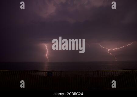 Blitzschlag über Gunfleet Sands Windpark vor Clacton auf See. Stockfoto